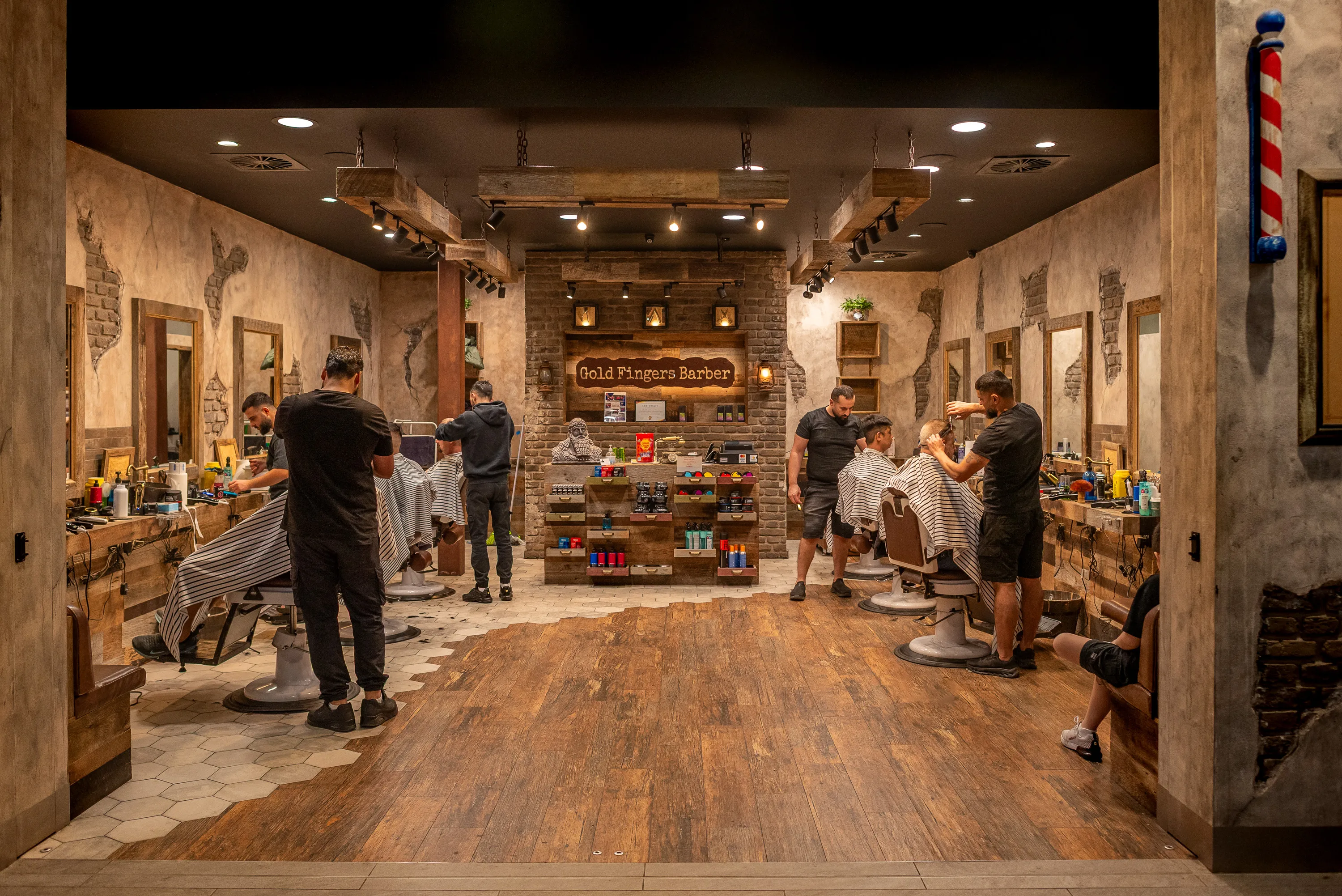 Inside a Gold Fingers Barber shop: timber floors, brick walls and a row of classic barber chairs