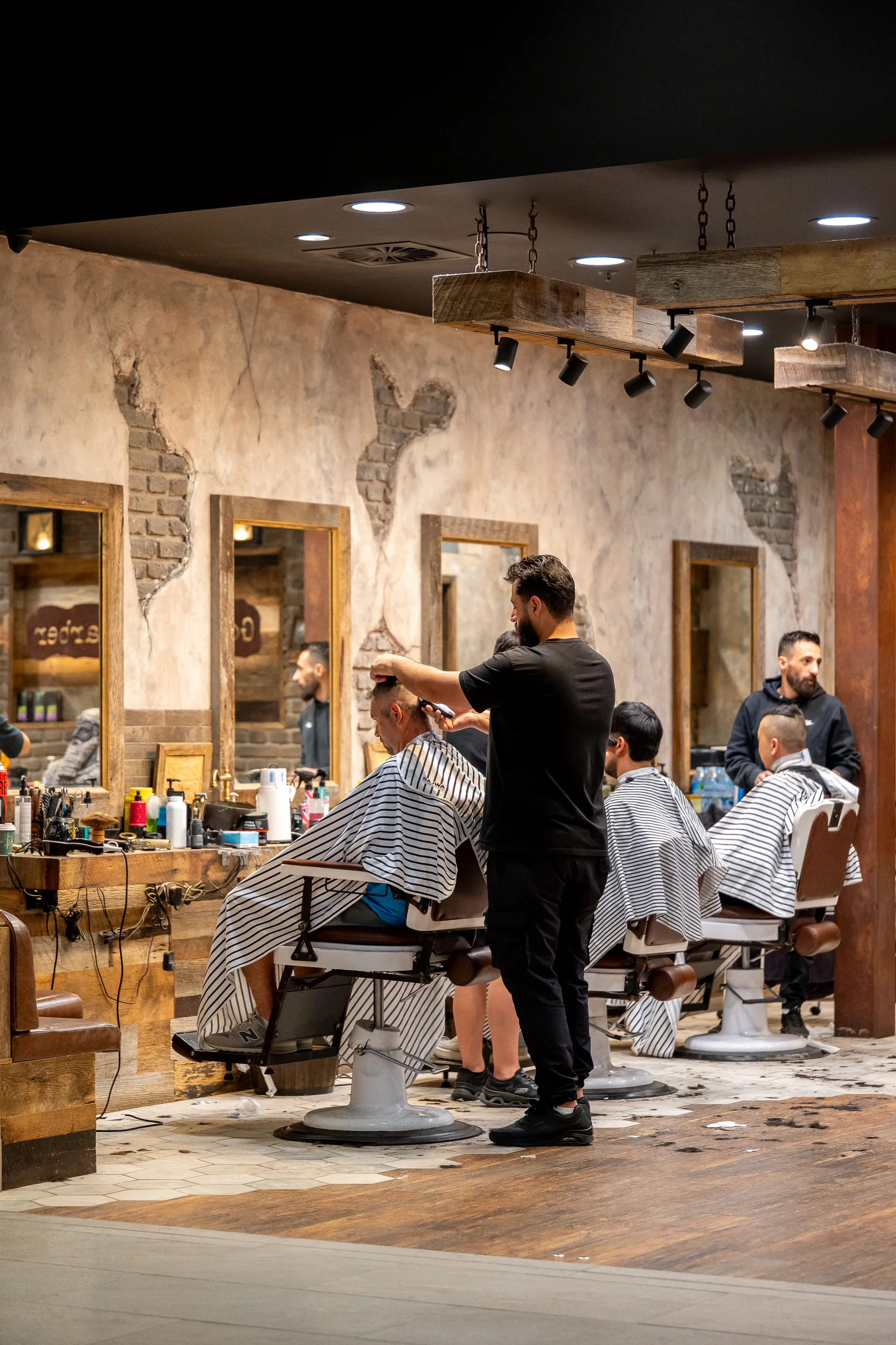 Barbers at work inside Gold Fingers Barber